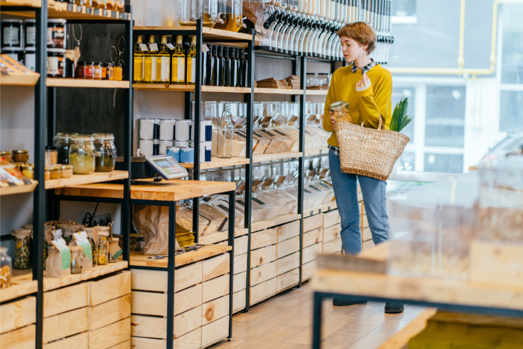 Nachhaltigkeit-für-Konsumenten Nachhaltige Produkte für bewussten Konsum - Frau im Laden mit Holzregalen