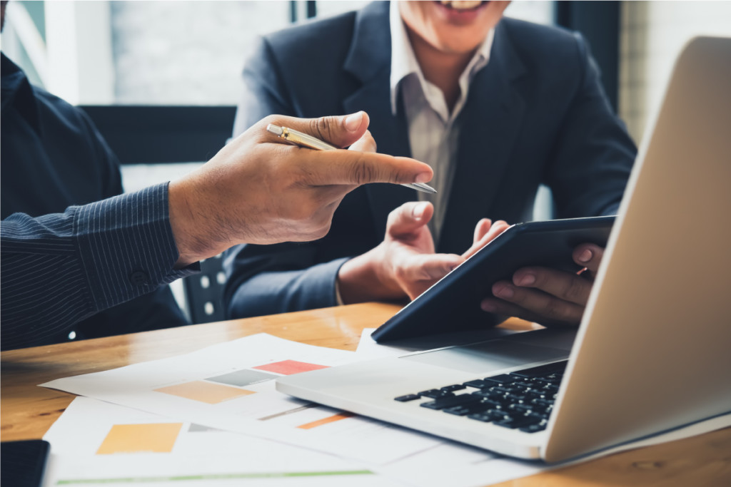 Nachhaltigkeit-für-Unternehmen-Lieferanten-Dienstleister Geschäftsprozesse digitalisieren - Business Partner in Anzug mit Tablet und Laptop