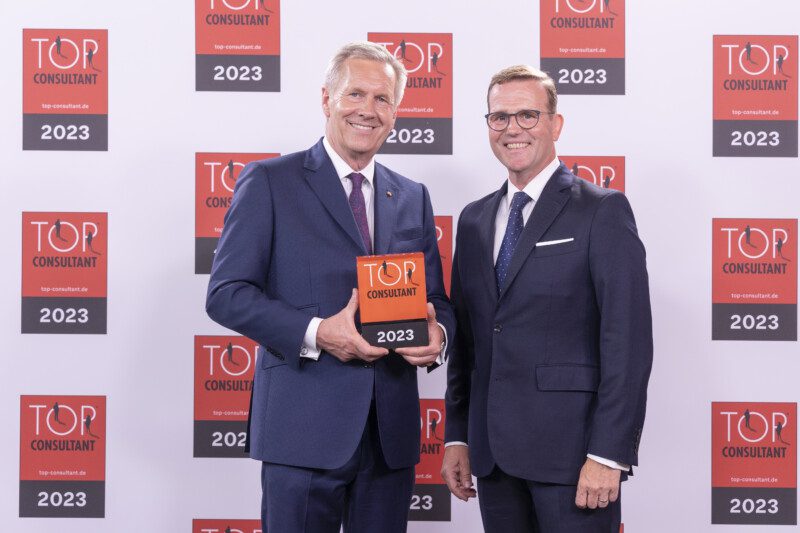 Auszeichnung als Top Consultant 2023: Christian Wulff übergibt das Siegel an Olaf Pagel